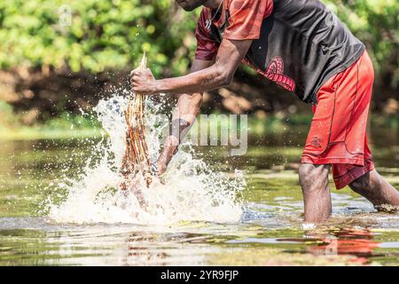 Pescatore che cattura pesce con un cesto nel fiume. Kalabo, Zambia, Africa Foto Stock