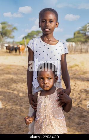 bestiame africano del villaggio, due bambine africane in piedi davanti alla penna delle mucche Foto Stock