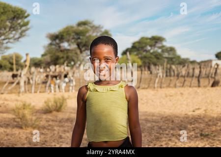 bestiame africano del villaggio, bambina africana in piedi di fronte alla penna delle mucche Foto Stock