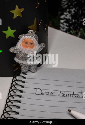 Lettera a Babbo Natale, vista dall'alto del taccuino con LE parole DI BABBO natale, un tavolo bianco con ornamenti natalizi Foto Stock