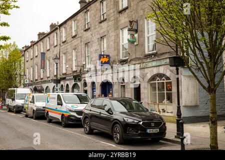 Irlanda, Contea di Mayo, Ballina, Pearse Street, negozi in un edificio in pietra grigia Foto Stock