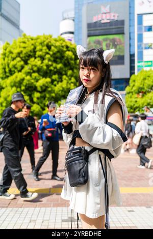 Adolescente giapponese che indossa un costume in bianco e nero con orecchie di gatti sulla testa, distribuendo volantini che pubblicizzano uno spettacolo. Comunemente chiamate promo Girls Foto Stock