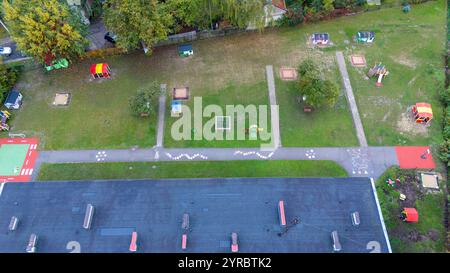 Vista aerea di un colorato parco giochi per bambini con varie strutture e spazi verdi. Foto Stock