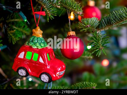 Ornamento di Natale per auto giocattolo appeso a un albero di Natale di abete balsamico. Foto Stock
