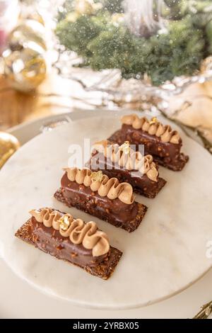 Torte di cioccolato alle nocciole con fiocchi d'oro cosparse di zucchero a velo durante il periodo natalizio Foto Stock