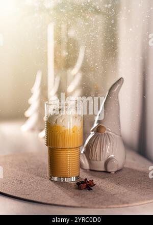 Scena natalizia con latte di zucca e spezie, panna montata e statuetta di gnomi Foto Stock