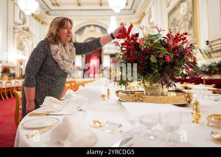 I ritocchi finali sono applicati ai fiori stagionali, da un fiorista reale, ai tavoli della sala da ballo di Buckingham Palace, Londra prima del banchetto di Stato per l'emiro del Qatar Sheikh Tamim bin Hamad al Thani, durante la sua visita di stato nel Regno Unito. Data foto: Martedì 3 dicembre 2024. Foto Stock