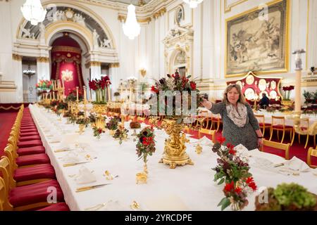 I ritocchi finali sono applicati ai fiori stagionali, da un fiorista reale, ai tavoli della sala da ballo di Buckingham Palace, Londra prima del banchetto di Stato per l'emiro del Qatar Sheikh Tamim bin Hamad al Thani, durante la sua visita di stato nel Regno Unito. Data foto: Martedì 3 dicembre 2024. Foto Stock