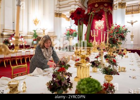 I ritocchi finali sono applicati ai fiori stagionali, da un fiorista reale, ai tavoli della sala da ballo di Buckingham Palace, Londra prima del banchetto di Stato per l'emiro del Qatar Sheikh Tamim bin Hamad al Thani, durante la sua visita di stato nel Regno Unito. Data foto: Martedì 3 dicembre 2024. Foto Stock