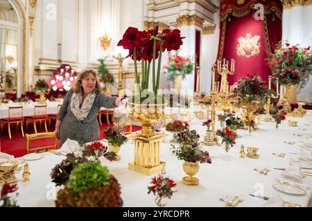I ritocchi finali sono applicati ai fiori stagionali, da un fiorista reale, ai tavoli della sala da ballo di Buckingham Palace, Londra prima del banchetto di Stato per l'emiro del Qatar Sheikh Tamim bin Hamad al Thani, durante la sua visita di stato nel Regno Unito. Data foto: Martedì 3 dicembre 2024. Foto Stock