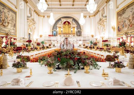 I ritocchi finali sono applicati ai fiori stagionali, da un fiorista reale, ai tavoli della sala da ballo di Buckingham Palace, Londra prima del banchetto di Stato per l'emiro del Qatar Sheikh Tamim bin Hamad al Thani, durante la sua visita di stato nel Regno Unito. Data foto: Martedì 3 dicembre 2024. Foto Stock