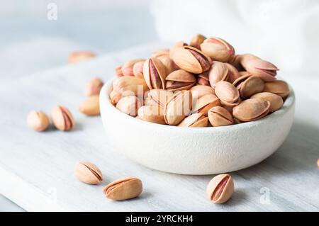 Pistacchio noce in noce sullo sfondo rustico in ciotola, composizione di pistacchi ottimo per una nutrizione sana e dietetica. Concetto di dadi Foto Stock