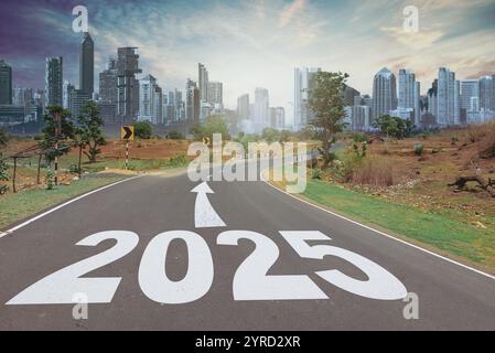 Nuovo anno 2025. Testo 2025 scritto sulla strada in mezzo alla strada al tramonto. Inizio anno nuovo Foto Stock