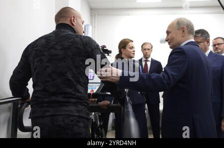 Mosca, Russia. 3 dicembre 2024. Il presidente russo Vladimir Putin, giusto, con un soldato durante l'addestramento su una gamba protesica presso il Priorov National Medical Research Center of Traumatology and Orthopaedics in occasione della giornata internazionale delle persone con disabilità, 3 dicembre 2024 a Mosca, Russia. Il centro sta fornendo riabilitazione e protesi per i soldati feriti nell'invasione Ucraina. Crediti: Gavriil Grigorov/piscina del Cremlino/Alamy Live News Foto Stock