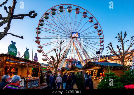 La vibrante ruota panoramica del Wantermaart (mercato invernale) nella città di Lussemburgo, Lussemburgo, circondato da bancarelle festose e visitatori. Foto Stock