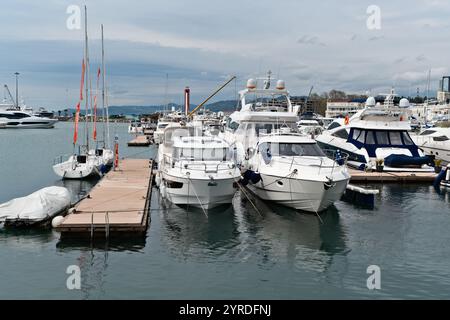 Barche a vela e yacht attraccati in un porticciolo sotto cieli nascosti vicino a una città costiera - Sochi, Russia, 14 aprile 2023 Foto Stock