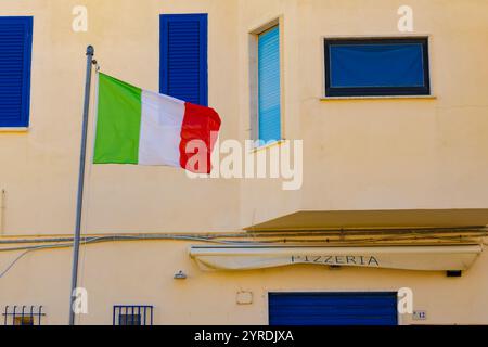 Flag of Italy e Italuan Pizza Cafe, pizzeria locale in Italia, bassa stagione, chiuso Foto Stock