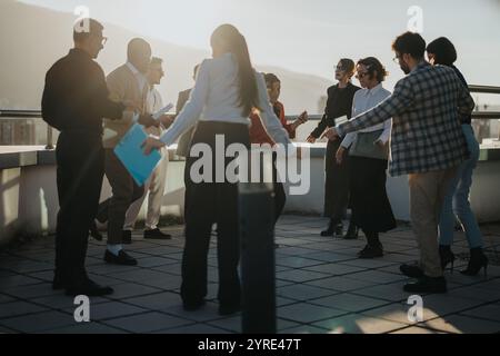 Colleghi d'affari multirazziali che festeggiano sul balcone della torre alta al tramonto Foto Stock