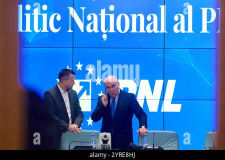 Bucarest, Romania. 3 dicembre 2024: Ilie Bolojan (R), presidente ad interim del Partito Nazionale Liberale (PNL), parla al telefono durante la riunione dell'Ufficio politico Nazionale del Partito Nazionale Liberale. Crediti: Lucian Alecu/Alamy Live News Foto Stock