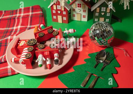 Decorazioni natalizie su un piatto sul tavolo. Surrealismo minimo Foto Stock