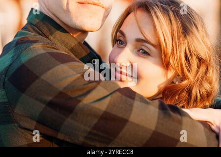 Un momento intimo tra una coppia che abbraccia la calda luce del tramonto. Foto Stock