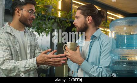 Colleghi maschi amici amici amici uomini multietnici partner commerciali colleghi arabi ragazzi caucasici uomini d'affari liberi professionisti parlare ridere gossip friendly Foto Stock