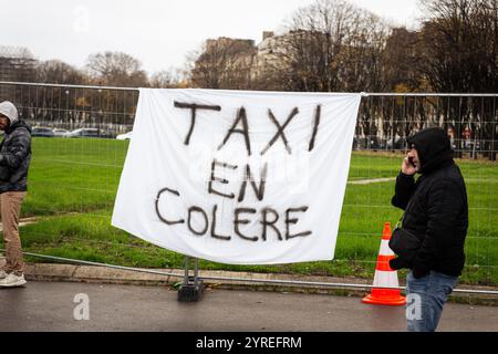 Parigi, Francia. 3 dicembre 2024. Uno striscione che dice "taxi in collera" visto durante la dimostrazione dei tassisti francesi. Il secondo giorno di dimostrazioni di tassisti in Francia, decine di veicoli hanno bloccato le strade vicino all'Assemblea Nazionale in una protesta all'Esplanade des Invalides, a Parigi. I lavoratori chiedono l'abbandono delle misure che minacciano il trasporto di taxi per i pazienti, combattono la concorrenza illegale, promuovono i taxi come servizio pubblico essenziale. Credito: SOPA Images Limited/Alamy Live News Foto Stock