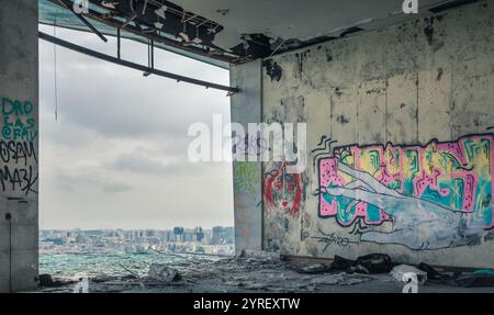 Lisbona attraverso la finestra del ristorante panoramico abbandonato di Monsanto, caratterizzato da graffiti artistici sulle pareti e detriti sul pavimento Foto Stock