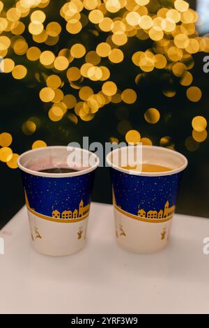 Un accogliente mercato natalizio caratterizzato da una tazza fumante di VIN brulé che cattura lo spirito festivo e il calore delle festività natalizie. Foto Stock