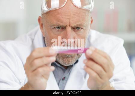 ricercatore maschile senior che svolge ricerche scientifiche Foto Stock