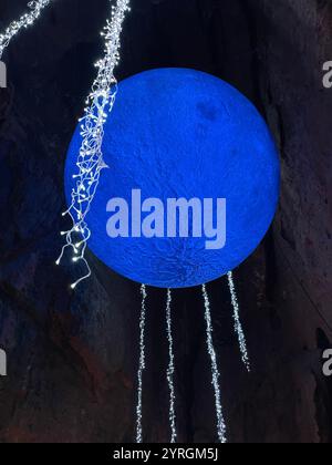 Scultura della luna blu e luci di Natale presso l'attrazione turistica Wookey Hole, Somerset, Regno Unito. Foto Stock