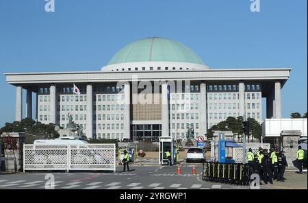 Seoul, Corea del Sud. 4 dicembre 2024. Gli agenti di polizia sono visti vicino all'Assemblea nazionale a Seoul, Corea del Sud, il 4 dicembre 2024. La legge marziale di emergenza della Corea del Sud, dichiarata dal presidente Yoon Suk-yeol martedì sera, è stata revocata mercoledì presto in una riunione di gabinetto dopo che il parlamento ha votato contro. La mozione per rimuovere l'ordine della legge marziale è stata approvata in una riunione di gabinetto convocata urgentemente, secondo diversi media. Crediti: Yao Qilin/Xinhua/Alamy Live News Foto Stock