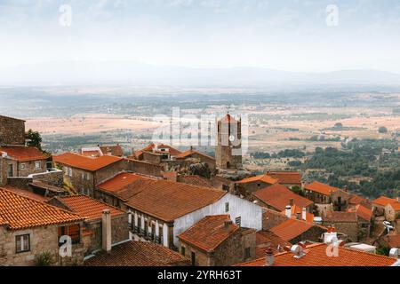 Il villaggio storico di Monsanto, costruito con case in pietra e tetti arancioni, mostra la sua imponente torre dell'orologio sul paesaggio di idanha a nova Foto Stock