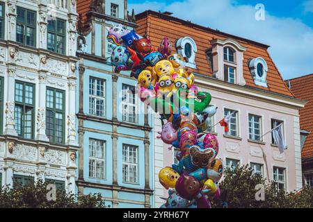 Palloncini dei personaggi dei cartoni animati che fluttuano di fronte a edifici colorati a danzica, in polonia, creando un'atmosfera vivace e giocosa nella storica città Foto Stock