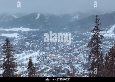 Vista panoramica della città di zakopane ricoperta di neve con piste da sci durante le nuvolose giornate invernali, abeti, monti tatra, polonia Foto Stock