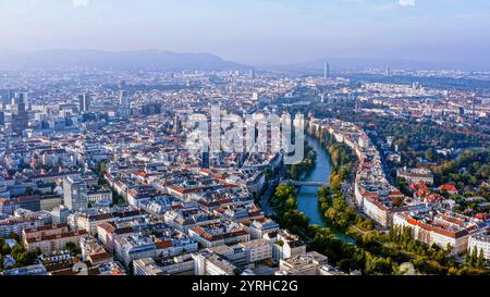 Vista aerea mozzafiato di Vienna, Austria, che mostra il paesaggio storico della città, il tranquillo canale del Danubio e i monumenti iconici sotto un cielo limpido. Foto Stock