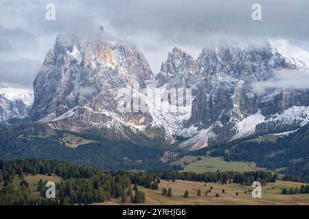 Spettacolare vista delle Dolomiti all'Alpe di Siusi, Italia, con vette torreggianti con cime innevate e nuvole che si spostano su un paesaggio verdeggiante A Dir Poco Foto Stock