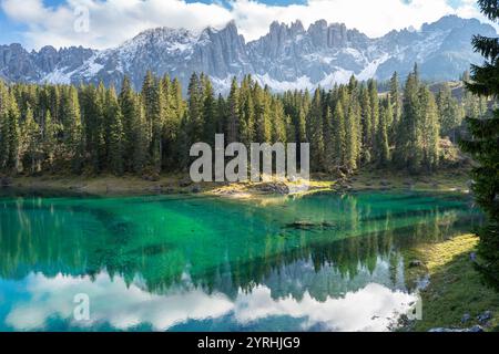 Splendida vista sul Lago di Carezza, che riflette i lussureggianti pini e le maestose Dolomiti, le tranquille acque color smeraldo impreziosiscono la mozzafiato landsca alpina Foto Stock