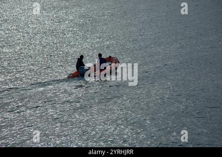 Nigrán,Pontevedra,Spagna;dicembre,03,2024:una vista aerea di due marinai in un gommone motorizzato, navigando attraverso acque calme. Foto Stock