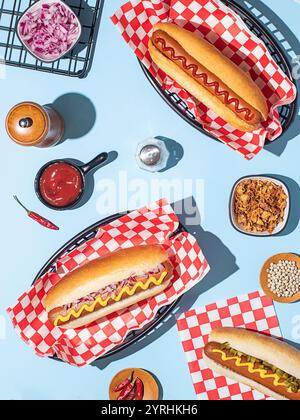 Shot di hot dog in cesti, accompagnati da condimenti e ingredienti come sottaceti, cipolle e peperoncino Foto Stock