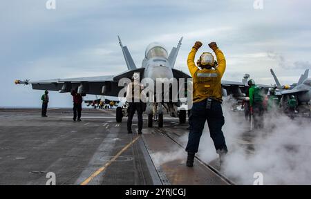 241201-N-GC617-1098 SOUTH CHINA SEA (1 dicembre 2024) Aviation Boatswain's Mate (Handling) 3a classe Daisy Rodrigues, di Los Angeles, dirige un F/A-18F Foto Stock