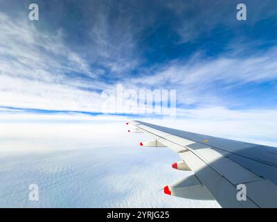 Vista dell'ala degli aeroplani delle british Airways che si innalza sopra le nuvole con un cielo blu vibrante sullo sfondo Foto Stock