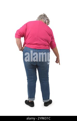 vista posteriore di una donna anziana accovacciata che guarda verso il basso e punta il dito a terra su sfondo bianco Foto Stock