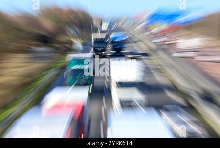 Schkeuditz, Germania. 26 novembre 2024. I veicoli si spostano sullo svincolo di Schkeuditzer Kreuz all'aeroporto di Lipsia/Halle. (Immagine con effetto zoom) il raccordo autostradale con le autostrade 9 e 14 nella conurbazione di Lipsia Halle è un importante centro di traffico e logistica. Crediti: Hendrik Schmidt/dpa/Alamy Live News Foto Stock