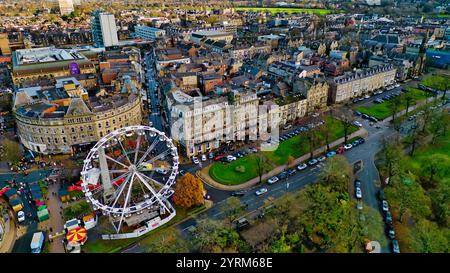 Vista aerea del centro città, con ruota panoramica, grande hotel, numerosi edifici, auto parcheggiate e spazi verdi. L'immagine mostra una combinazione di archi Foto Stock