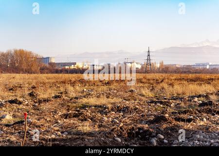 Preparazione di un nuovo sito per la costruzione di edifici residenziali nella periferia di Bishkek con vista sulle montagne, Kirghizistan. Foto Stock