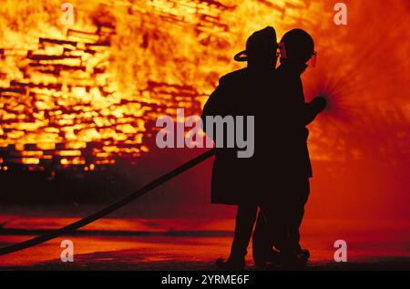 Sagoma dei pompieri davanti al fuoco Foto Stock