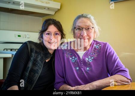 Nonna e nipote seduti vicini mentre posano per la telecamera a Ludington, Michigan, Stati Uniti. Foto Stock