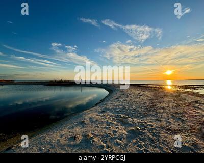 Un tramonto mozzafiato su Cape Cod, che proietta vivaci sfumature sul cielo e si riflette sulle acque tranquille, catturando la bellezza della natura. Foto Stock