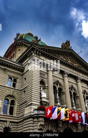 Splendido edificio del Parlamento Bundeshaus o Palazzo Federale con bandiere cantonali nella giornata nazionale e con nuvole di tempesta nella città di Berna, Canton Berna, Switz Foto Stock